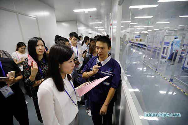 華億比科工作人員向采訪團(tuán)記者介紹鋰電池生產(chǎn)線